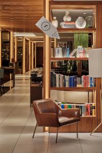 a leather chair in a room with books at Sheraton Grand Warsaw in Warsaw