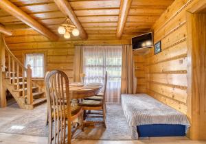 a dining room in a log cabin with a table and chairs at Domki u Marii- agroturystyka in Bańska Niżna