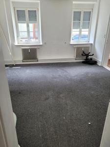 an empty room with two windows and a chair at Simple Übernachtungsmöglichkeit in Krumbach