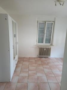 an empty room with a tiled floor and a window at Simple Übernachtungsmöglichkeit in Krumbach