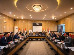 a group of people sitting at a long table in a room at Modern Palace Hotel in Al Fayşalīyah