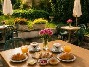 a table with cups of coffee and croissants on it at La Diligence in Lepin-le-Lac