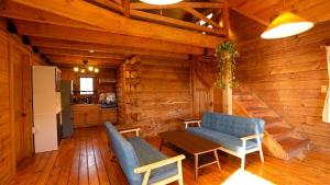 a living room with a table and chairs in a log cabin at ログハウス SakuraFamiliar in Kawazu +12 photos