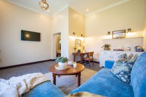 a living room with a blue couch and a table at Troutbeck Resort in Nyanga