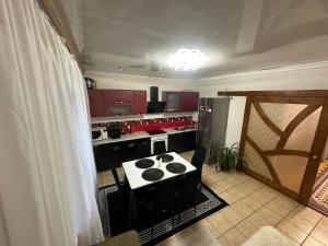 a kitchen with red cabinets and a stove top oven at Fetal Hut - Плідна Хата in Verkhovyna