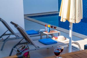 a chair and a table with wine glasses and a pool at Villa Kaş B in Kaş +18 photos