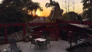 a patio with a table and chairs and an umbrella at Pousada Vila Taquaras in Balneário Camboriú +74 photos