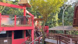 a playground with a red building and a tree at Pousada Vila Taquaras in Balneário Camboriú