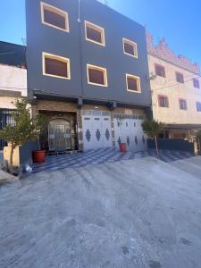 a large building with a gate in front of it at Atouli Suites in Nador