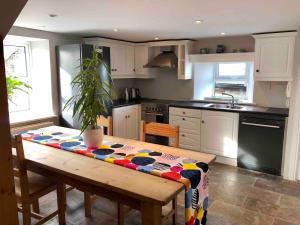 a kitchen with a wooden table and a kitchen with auclear at Countryside Cottage in Ardee