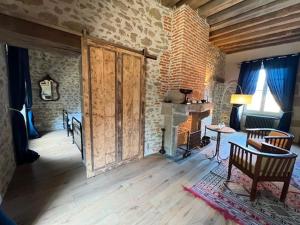 a living room with a fireplace and a stone wall at Lieu dit La Chassagne in Saint-Hilaire-le-Château