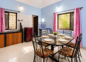 a dining room with a table and chairs in a kitchen at Royalstar Resort in Vagator