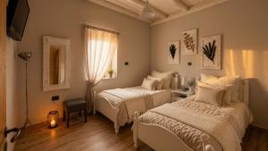a bedroom with two beds and a desk and a mirror at Villa Katrinia in Sitia