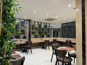 a restaurant with tables and chairs and plants at Modern Palace Hotel in Al Fayşalīyah