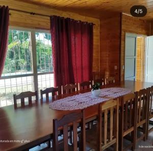 a dining room with a large wooden table and chairs at Quinta Bommerl in Paso de la Patria