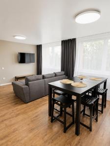 a living room with a table and a couch at Stiklo Apartamentai in Radviliškis