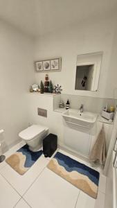 a white bathroom with a toilet and a sink at Lovely room in Chelsea in London +3 photos