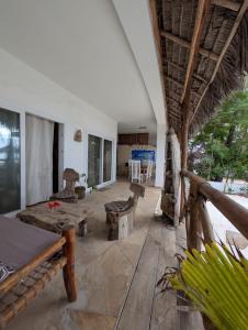 a porch of a house with a table and benches at Thamani Apartment Zanzibar in Pwani Mchangani