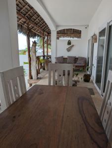 a dining room with a wooden table and chairs at Thamani Apartment Zanzibar in Pwani Mchangani