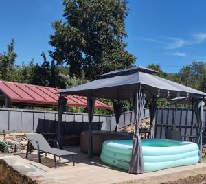 a black umbrella with a pool and a table and chairs at Casa Ramos in Mogadouro