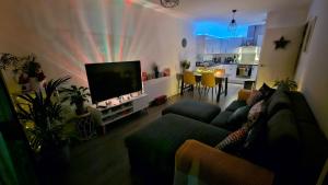 a living room with a couch and a flat screen tv at Lovely room in Chelsea in London