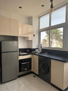 a kitchen with a washer and dryer and a window at Stodio sofia in Essaouira