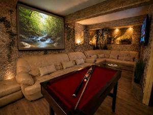 a living room with a couch and a pool table at Sofia Private Wellness Apartman Prague - Sauna & Jacuzzi in Prague