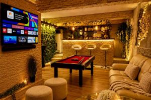 a living room with a pool table and a tv at Sofia Private Wellness Apartman Prague - Sauna & Jacuzzi in Prague +22 photos