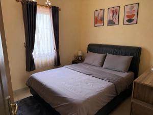 a bedroom with a bed with blue sheets and a window at Vrh Beograda Villa 2 in Zaječar