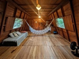 a hammock in the middle of a room at Chalé da Mata, Ilha de Cotijuba in Belém
