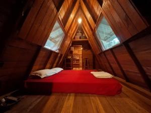 a bedroom with a red bed in a tree house at Chalé da Mata, Ilha de Cotijuba in Belém