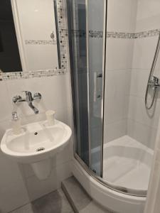 a white bathroom with a sink and a shower at Mirato in Władysławowo +35 photos