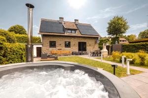 a house with a hot tub in the yard at Traumfabrik Eifel mit Sauna & Whirlpool in Monschau