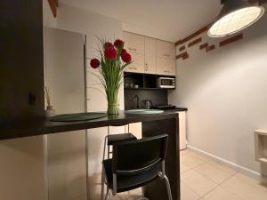 a kitchen with a vase with red flowers on a counter at Cicha Przystań w Centrum -Mała Sienkiewicza in Kielce