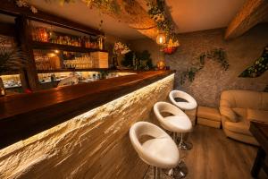 a bar with two white chairs and a counter at Sofia Private Wellness Apartman Prague - Sauna & Jacuzzi in Prague