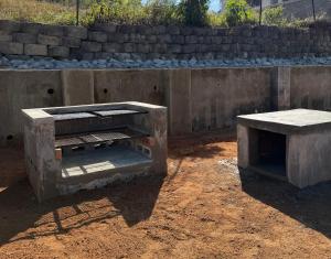 two concrete benches sitting on the dirt in front of a wall at Ekhaya Loft in Mbabane