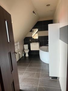 a bathroom with a white tub and a toilet at Apartament Piętrowy 138m2 in Gniezno