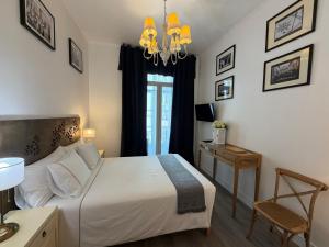 a bedroom with a bed and a table and a chandelier at Lisbon Downtown Inn in Lisbon