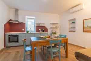 a kitchen and dining room with a wooden table and chairs at PianoPiano Nel cuore del borgo di Viterbo P1 in Viterbo