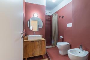 a bathroom with a sink and a toilet and a mirror at PianoPiano Nel cuore del borgo di Viterbo P1 in Viterbo