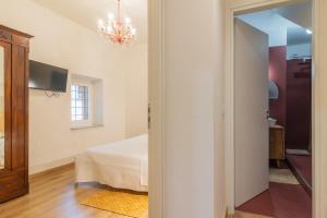 a bedroom with a bed and a chandelier at PianoPiano Nel cuore del borgo di Viterbo P1 in Viterbo