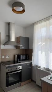a kitchen with a stove top oven next to a window at FeWo Augusta in Neustrelitz