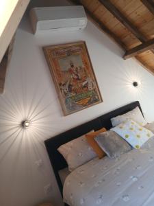 a bedroom with a bed and a painting on the wall at Aux charmes flamands in Wemaers-Cappel