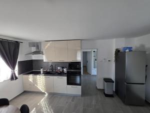 a kitchen with white cabinets and a refrigerator at UP & DOWN Holiday House in Donji Prozor