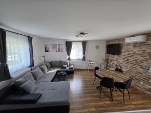 a living room with a couch and a brick wall at UP & DOWN Holiday House in Donji Prozor
