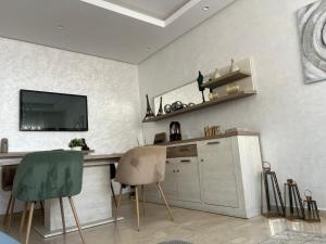 a kitchen with two chairs and a counter with a tv at infinity by Ghita in Rabat