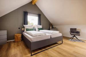a bedroom with a bed and a chair at Traumnest Eifel mit Sauna & Whirlpool in Monschau