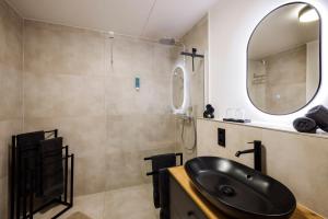a bathroom with a black sink and a mirror at Traumnest Eifel mit Sauna & Whirlpool in Monschau +41 photos