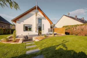 a small white house with a grass yard at Traumnest Eifel mit Sauna & Whirlpool in Monschau