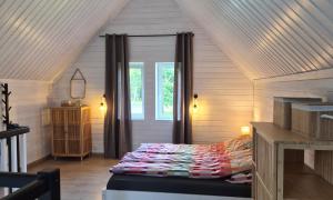 a bedroom with a bed in a attic at Las Tu Las Tam in Chudaczewko